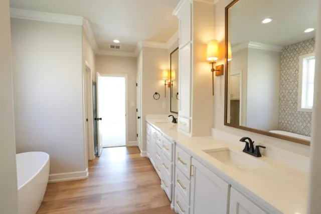 a bathroom with a double vanity sink a mirror and a bathtub