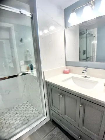 a bathroom with a sink a mirror and a shower