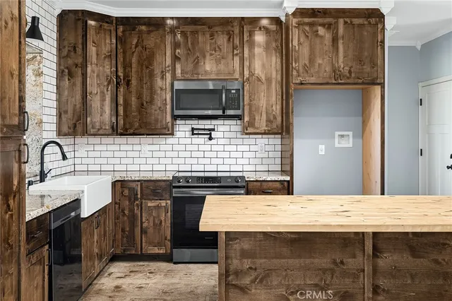 a view of kitchen with granite countertop a sink and a stove