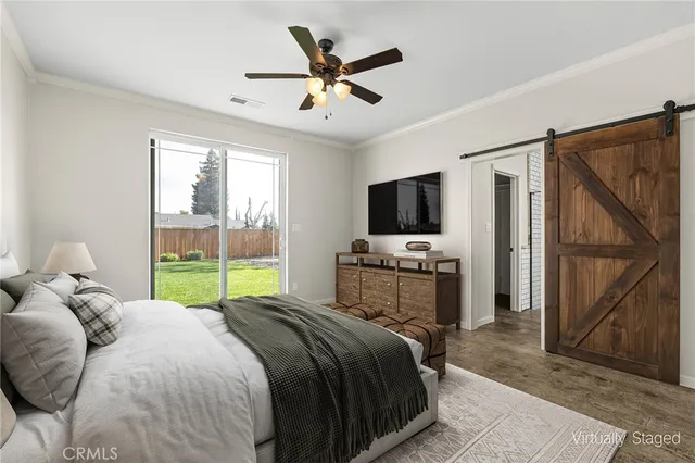 a bedroom with a bed flat screen tv and a large window