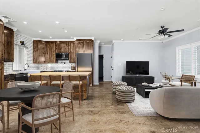 a living room with furniture a flat screen tv and kitchen view