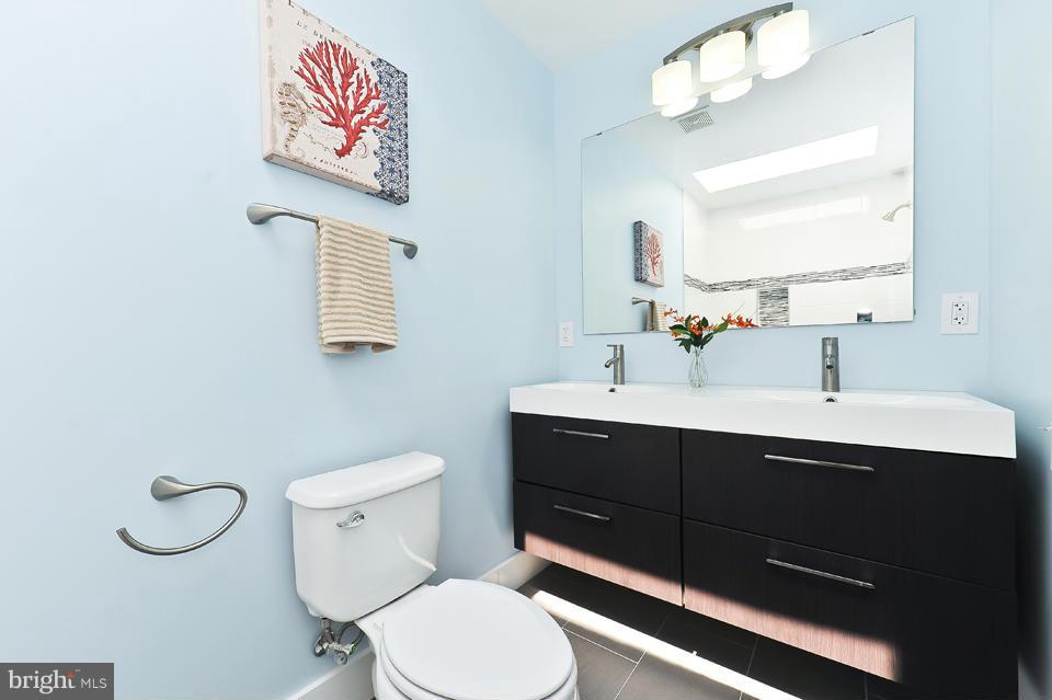 1110 Orren Street Northeast Washington, DC 20002 - Photo 21 of 30 a bathroom with a toilet a sink and mirror