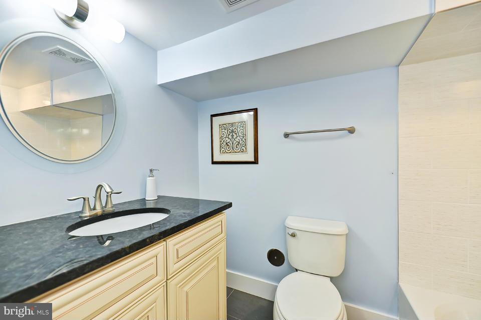 1110 Orren Street Northeast Washington, DC 20002 - Photo 24 of 30 a bathroom with a granite countertop toilet a sink and mirror