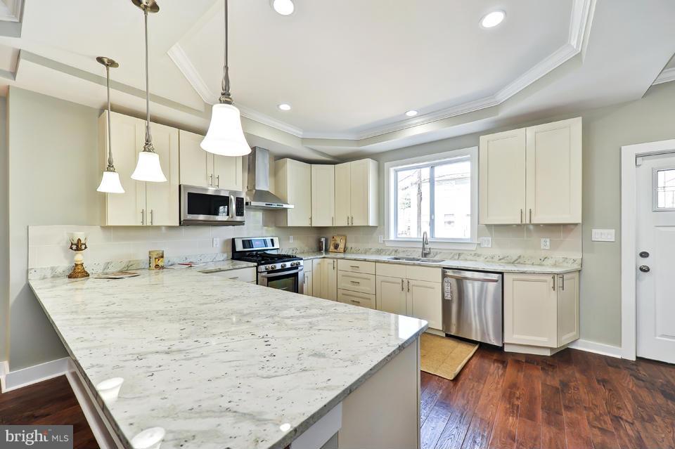 1110 Orren Street Northeast Washington, DC 20002 - Photo 9 of 30 a kitchen with stainless steel appliances granite countertop wooden cabinets a sink a stove a kitchen island and chairs