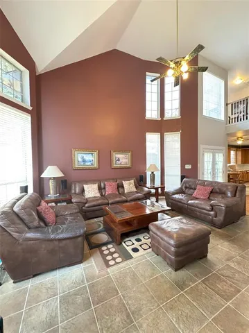 a living room with furniture a large window and a chandelier
