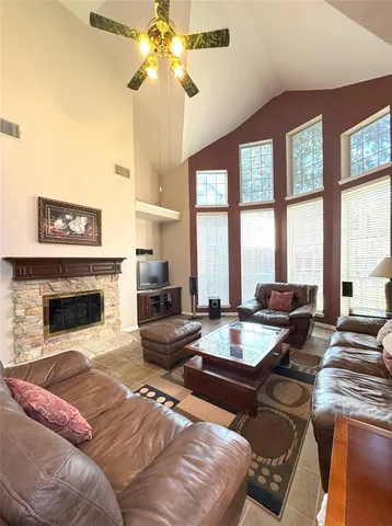 a living room with fireplace furniture and a large window