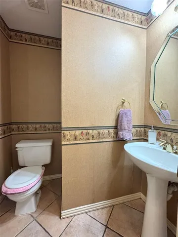 a bathroom with a toilet a sink and a mirror