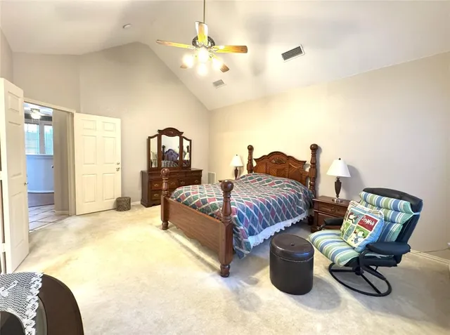 a spacious bedroom with a bed and a chandelier