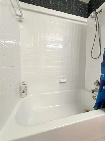 a bathroom with a bath tub with a shower
