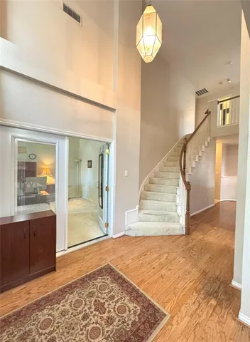 a view of a hallway with wooden floor and a chandelier