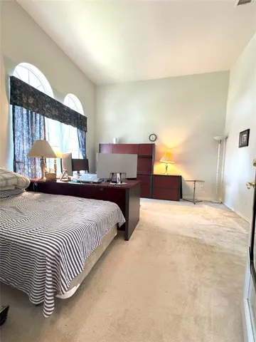 a large bedroom with a bed and window