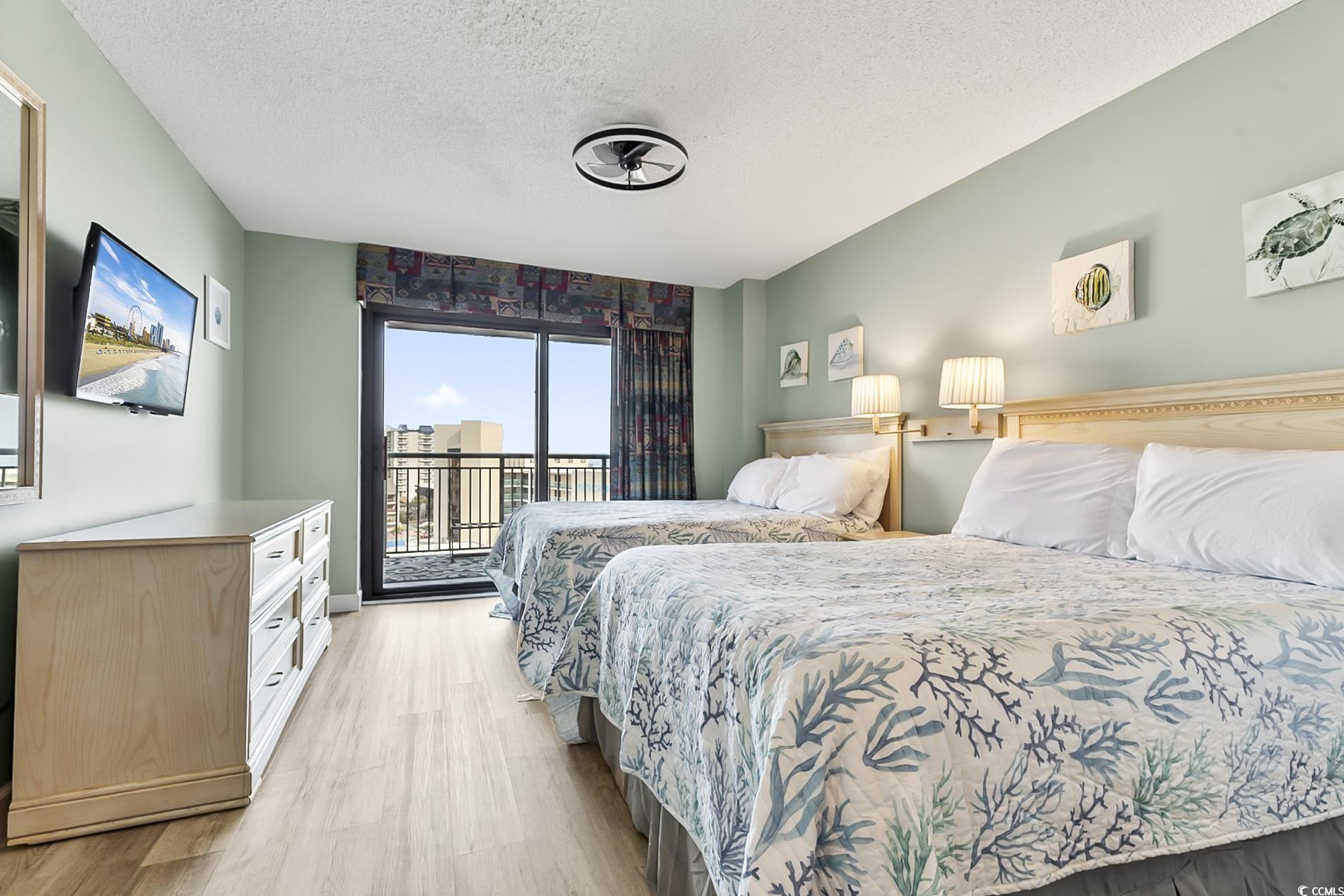 205 74th Avenue North, Unit 708 Myrtle Beach, SC 29572 - Photo 14 of 38 Bedroom with a textured ceiling, access to outside, and light wood finished floors
