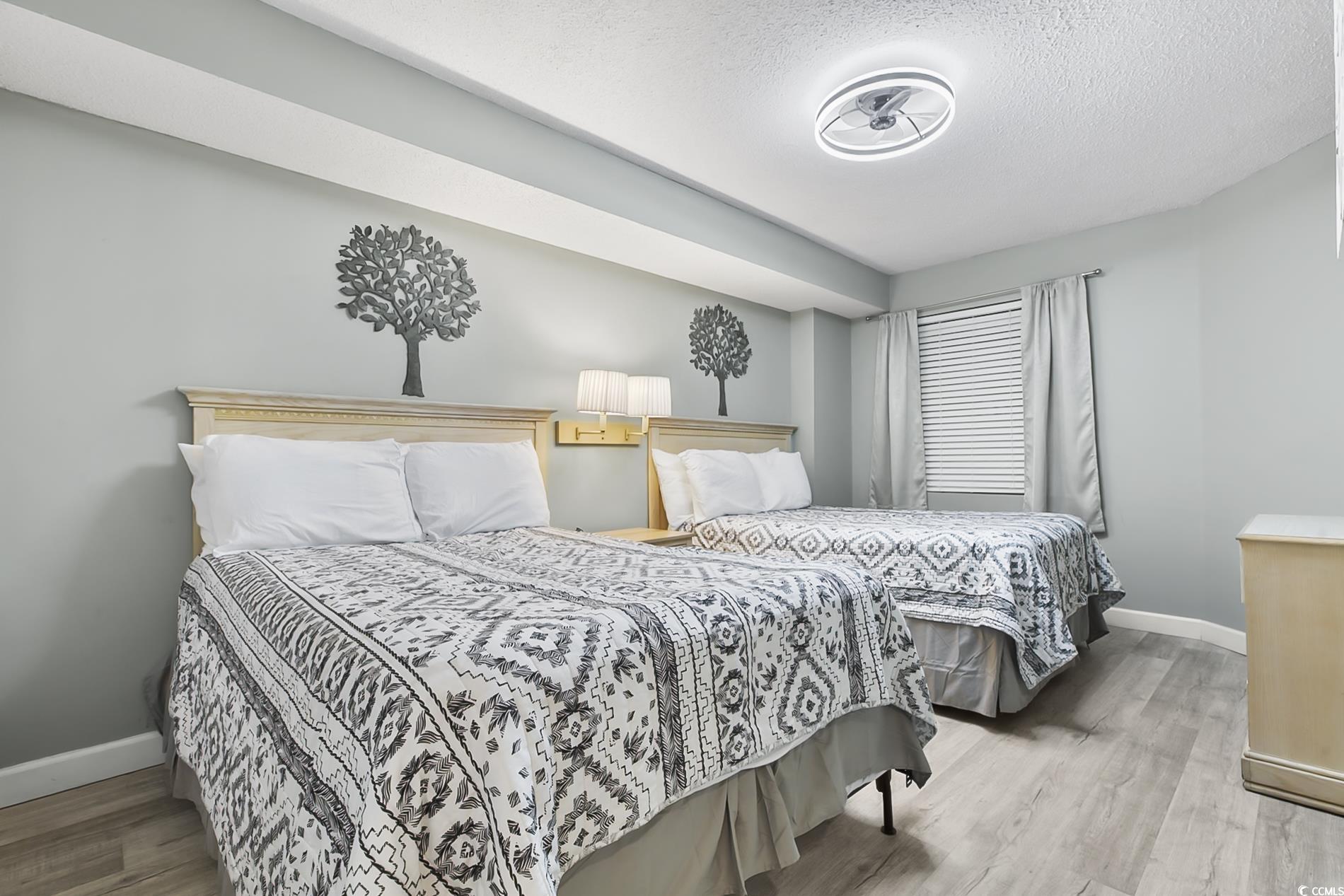 205 74th Avenue North, Unit 708 Myrtle Beach, SC 29572 - Photo 19 of 38 Bedroom featuring a textured ceiling and light wood-style flooring