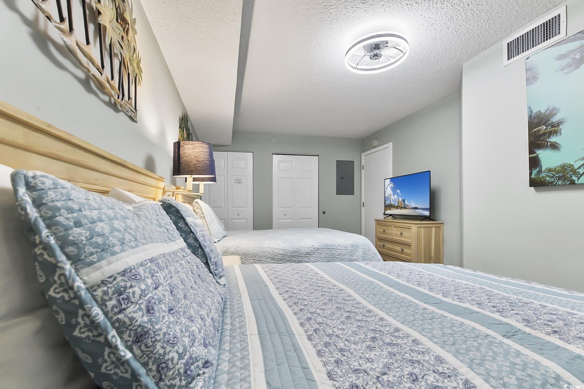 205 74th Avenue North, Unit 708 Myrtle Beach, SC 29572 - Photo 23 of 38 Bedroom featuring a textured ceiling, two closets, and electric panel