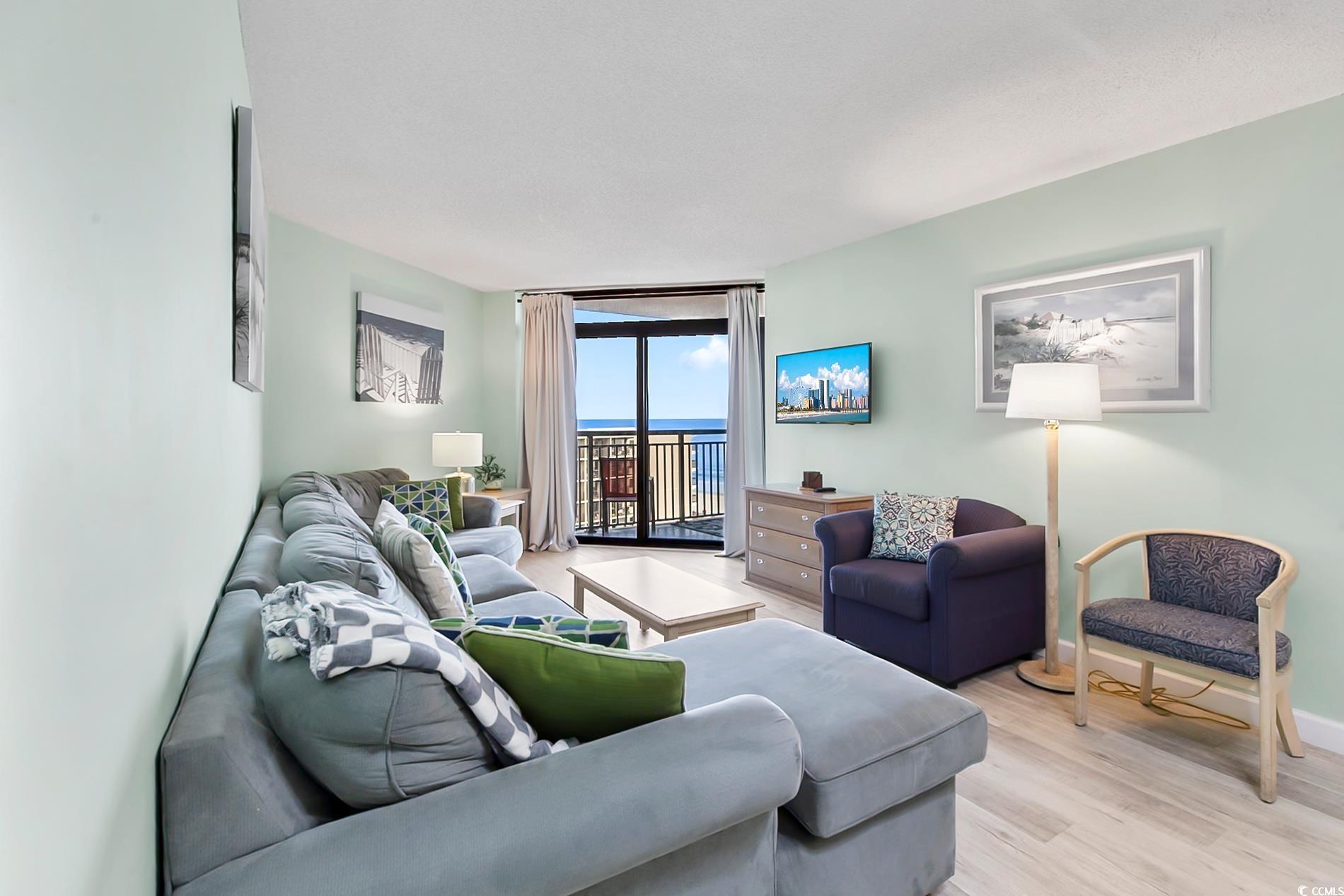 205 74th Avenue North, Unit 708 Myrtle Beach, SC 29572 - Photo 3 of 38 Living room with a wall of windows and light wood-type flooring