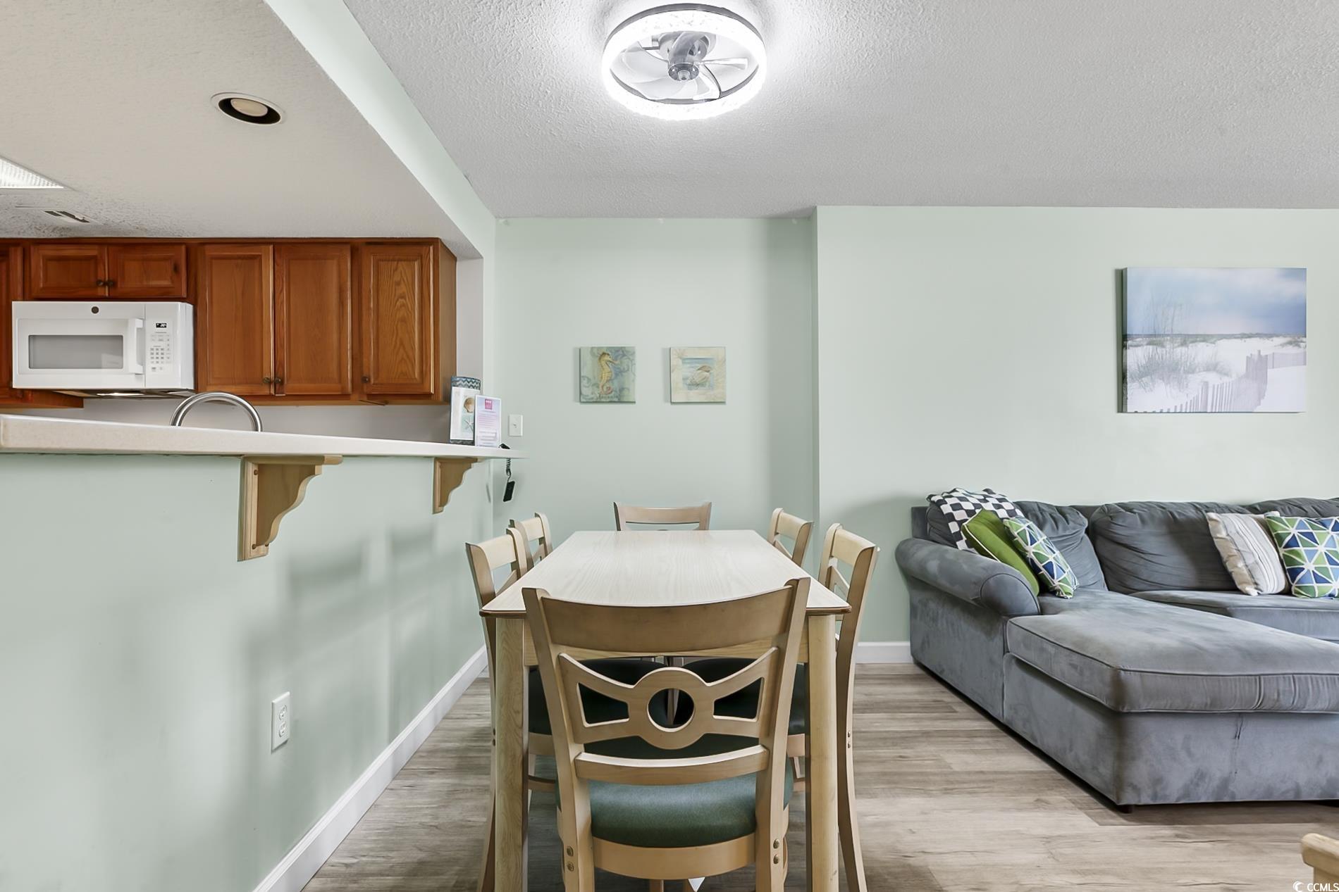 205 74th Avenue North, Unit 708 Myrtle Beach, SC 29572 - Photo 8 of 38 Dining room with light wood-style flooring and a textured ceiling