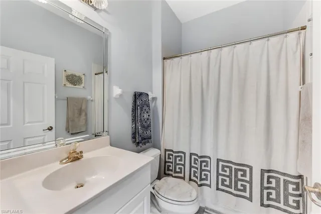 a bathroom with a toilet a sink and a mirror