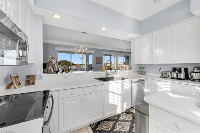 a kitchen with white cabinets and appliances
