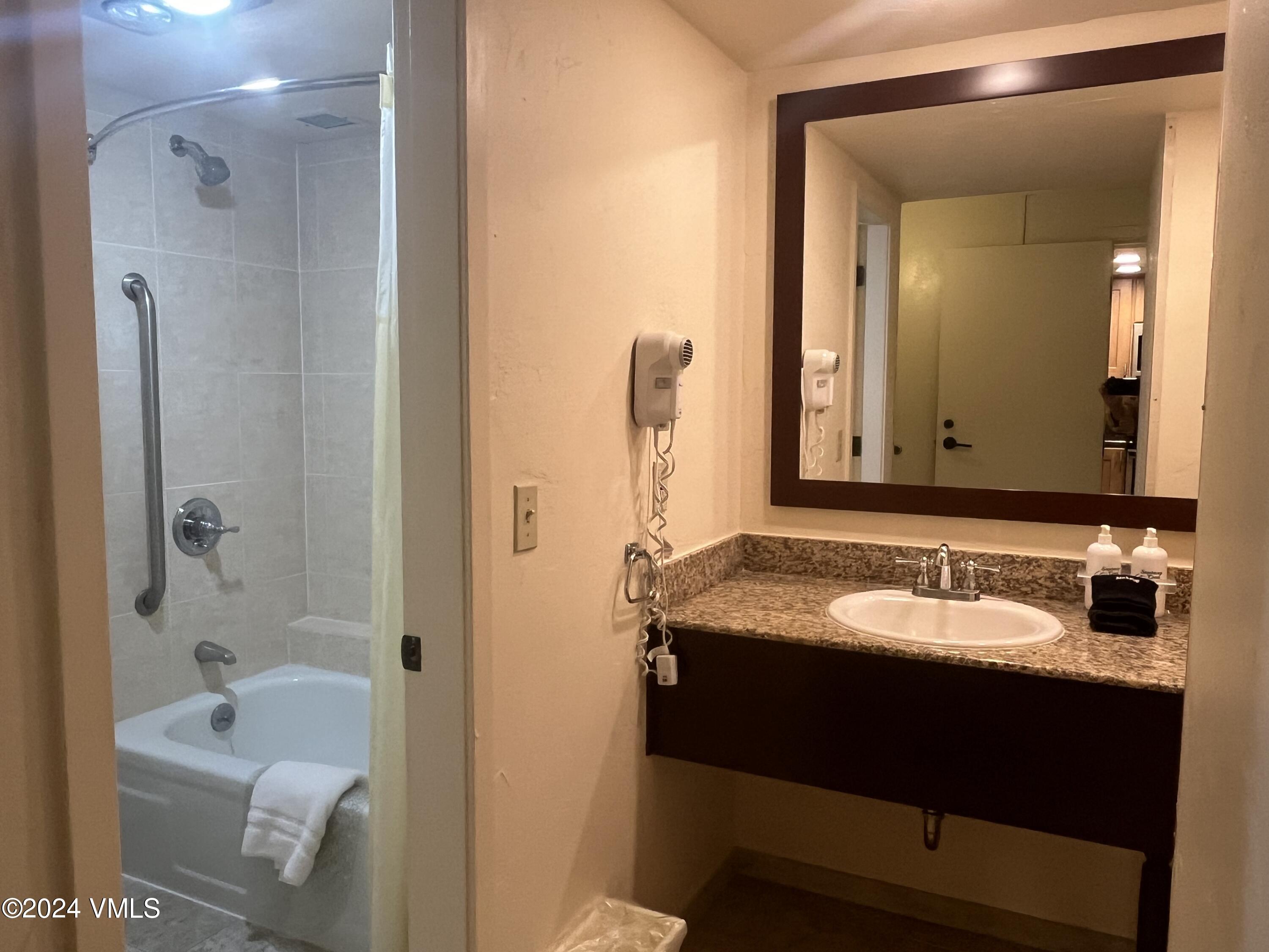 1020 Vail View Drive, Unit 340847 Vail, CO 81657 - Photo 8 of 25 a bathroom with a granite countertop tub sink and mirror