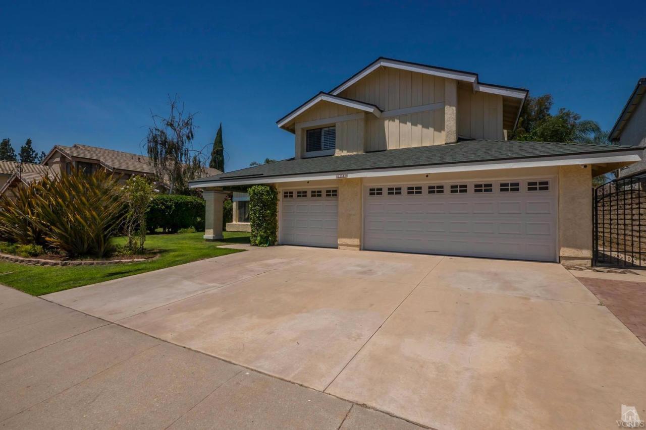 11529 East Buttercreek Road Moorpark, CA 93021 - Photo 1 of 36 a front view of a house with a yard and garage