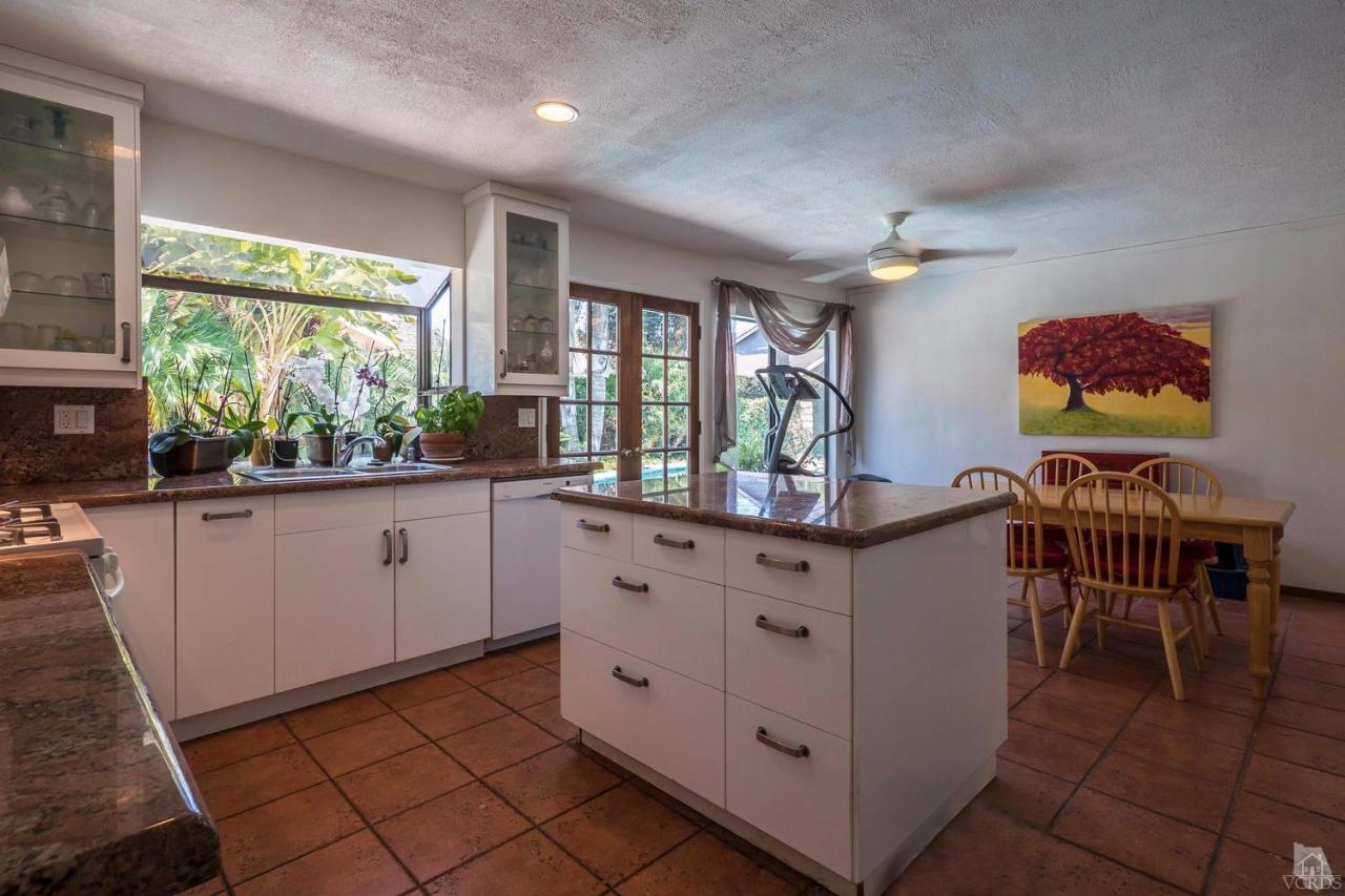 11529 East Buttercreek Road Moorpark, CA 93021 - Photo 13 of 36 a kitchen with granite countertop a stove a sink a dining table and chairs