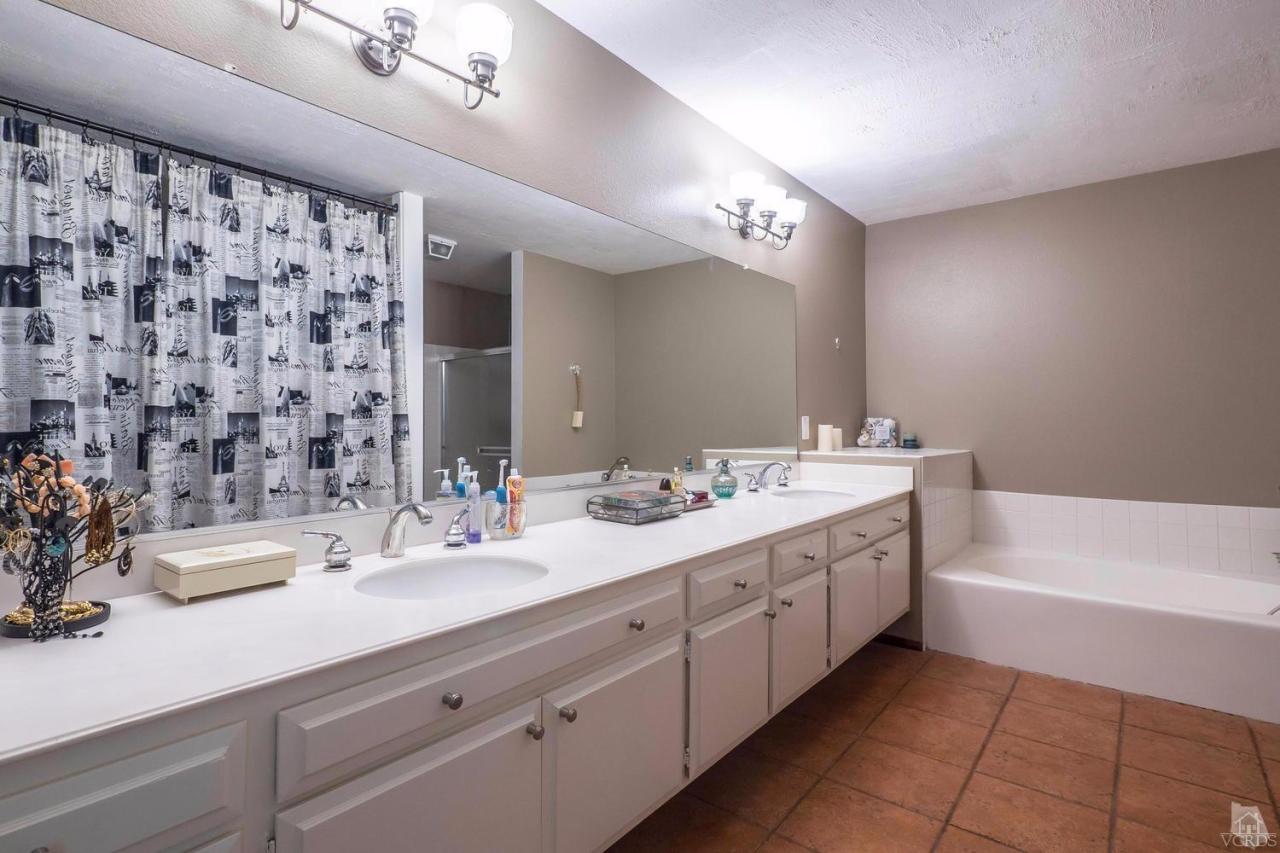11529 East Buttercreek Road Moorpark, CA 93021 - Photo 25 of 36 a spacious bathroom with a double vanity sink a mirror and a bathtub