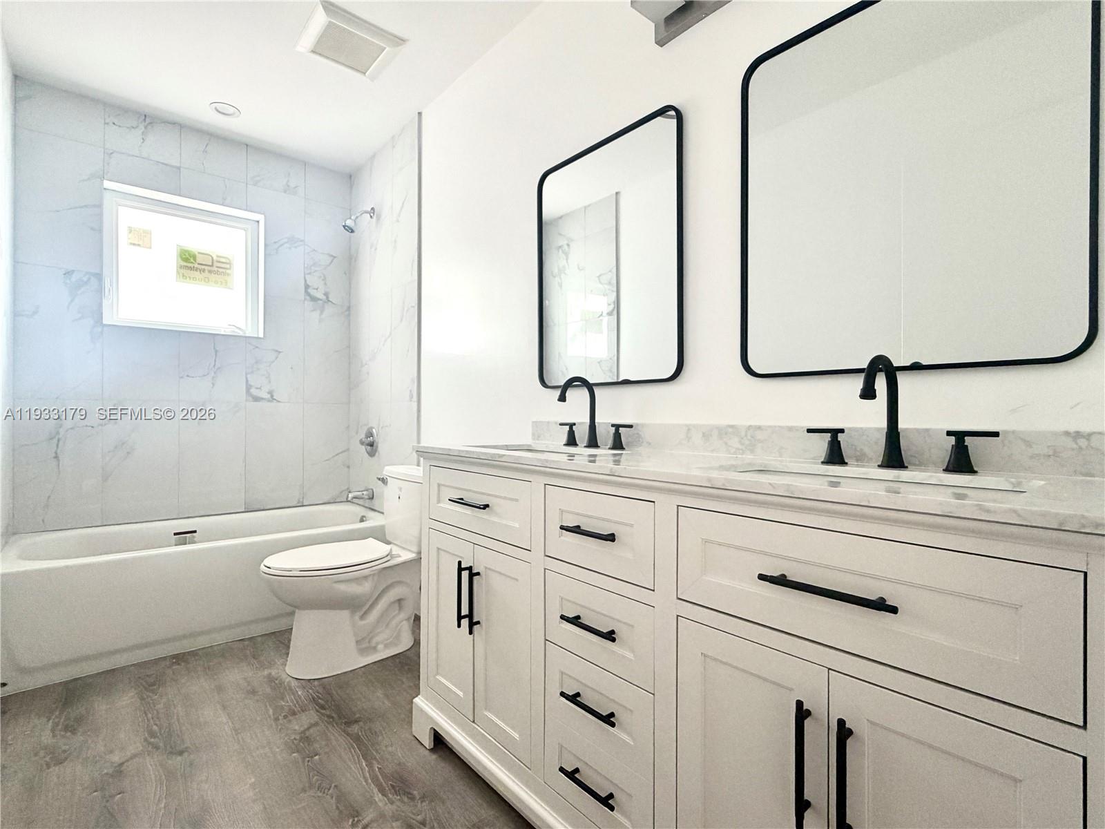 1629 Northwest 40th Street Miami, FL 33142 - Photo 5 of 17 a bathroom with a double vanity sink a toilet and a bathtub