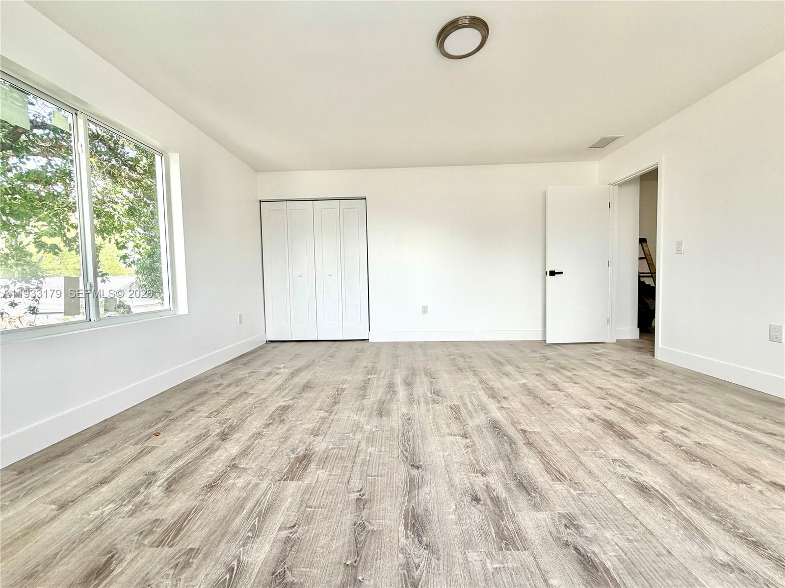 1629 Northwest 40th Street Miami, FL 33142 - Photo 6 of 17 a view of empty room with wooden floor and fan