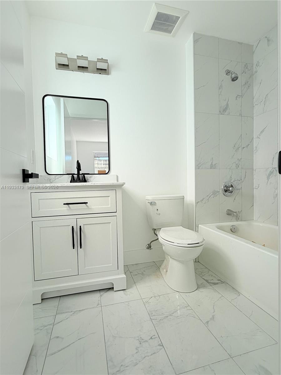 1629 Northwest 40th Street Miami, FL 33142 - Photo 7 of 17 a spacious bathroom with a toilet sink and mirror