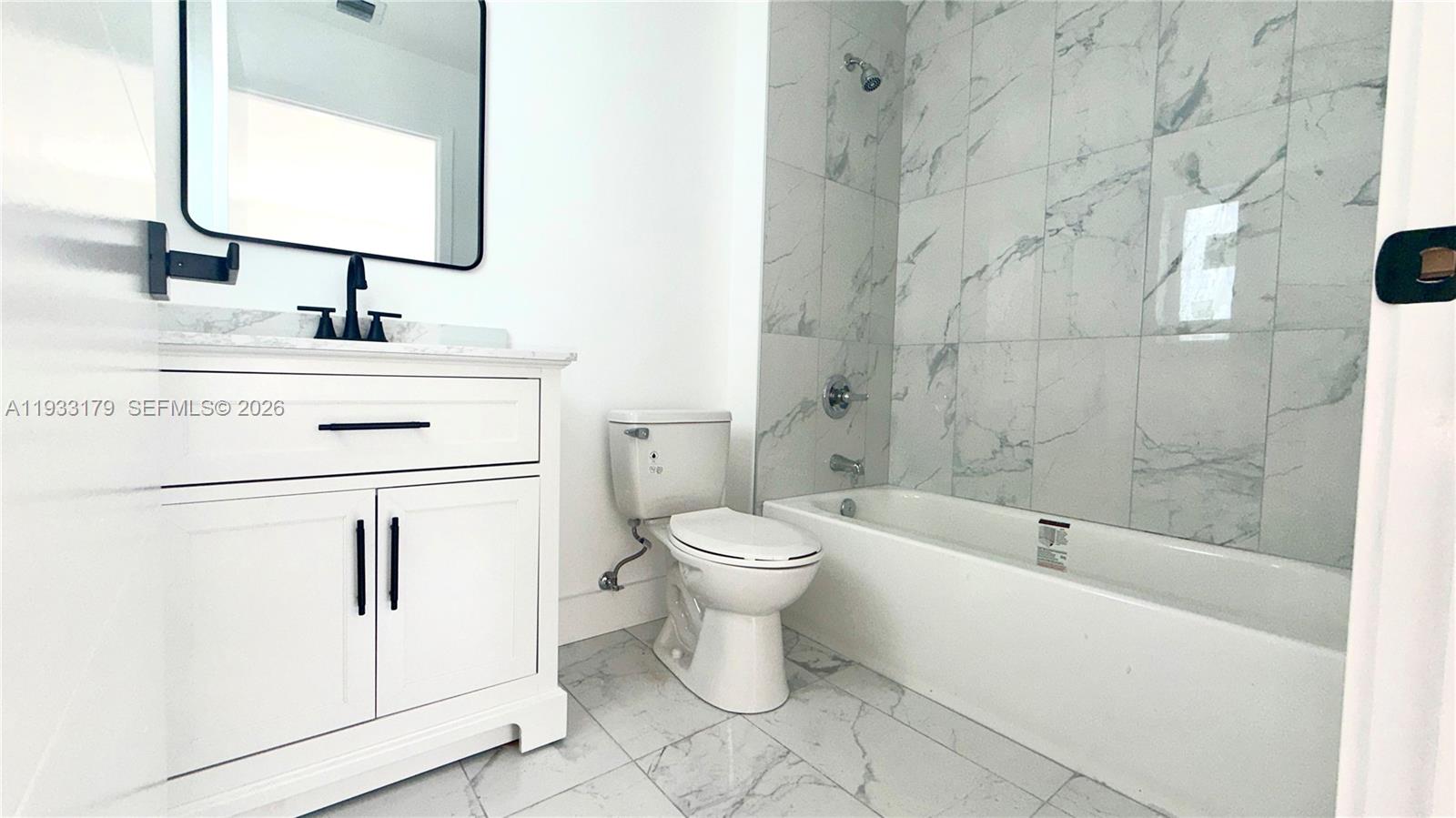 1629 Northwest 40th Street Miami, FL 33142 - Photo 9 of 17 a bathroom with a toilet sink and a mirror