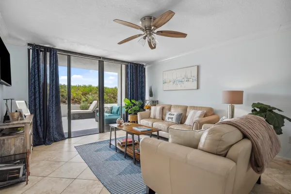 a living room with furniture and a large window with garden view