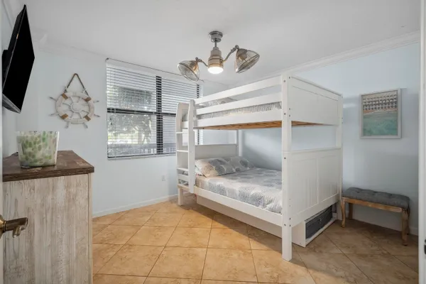 a bedroom with a bed and a flat tv screen on the wall