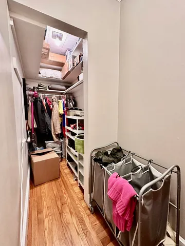 a view of walk in closet with clothes and shoes