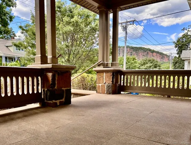 a view of a black and white wooden bench in front of a building