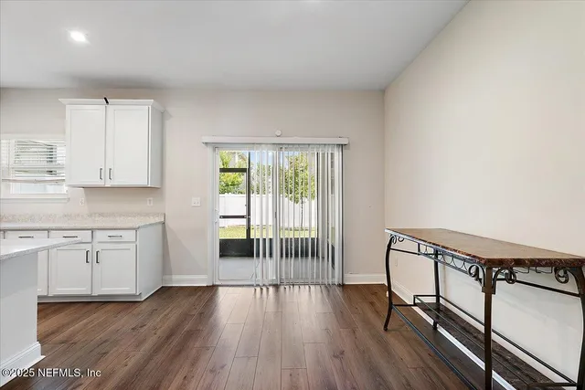 a view of a kitchen with wooden floor and a window