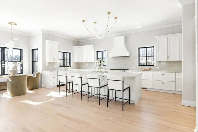 a kitchen with stainless steel appliances granite countertop a stove a sink a dining table and chairs