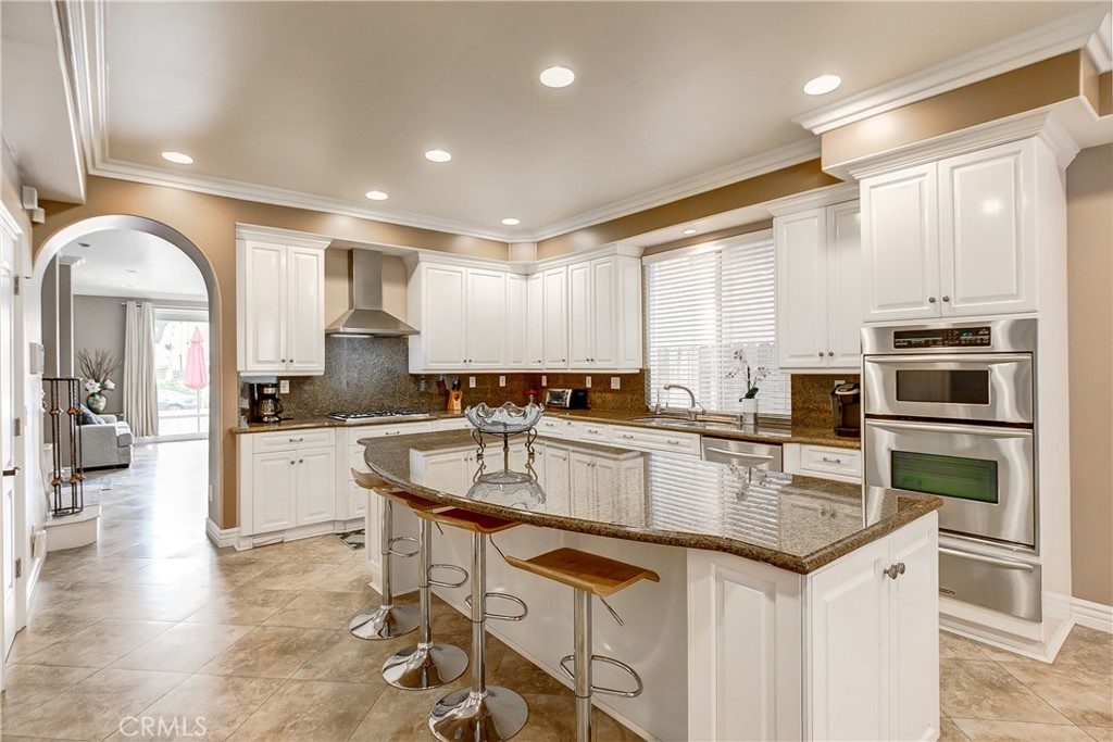213 Baltimore Avenue Huntington Beach, CA 92648 - Photo 16 of 50 a kitchen with granite countertop a stove top oven sink and cabinets