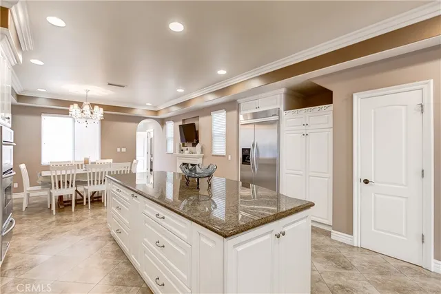 an open kitchen with granite countertop a sink and white cabinets