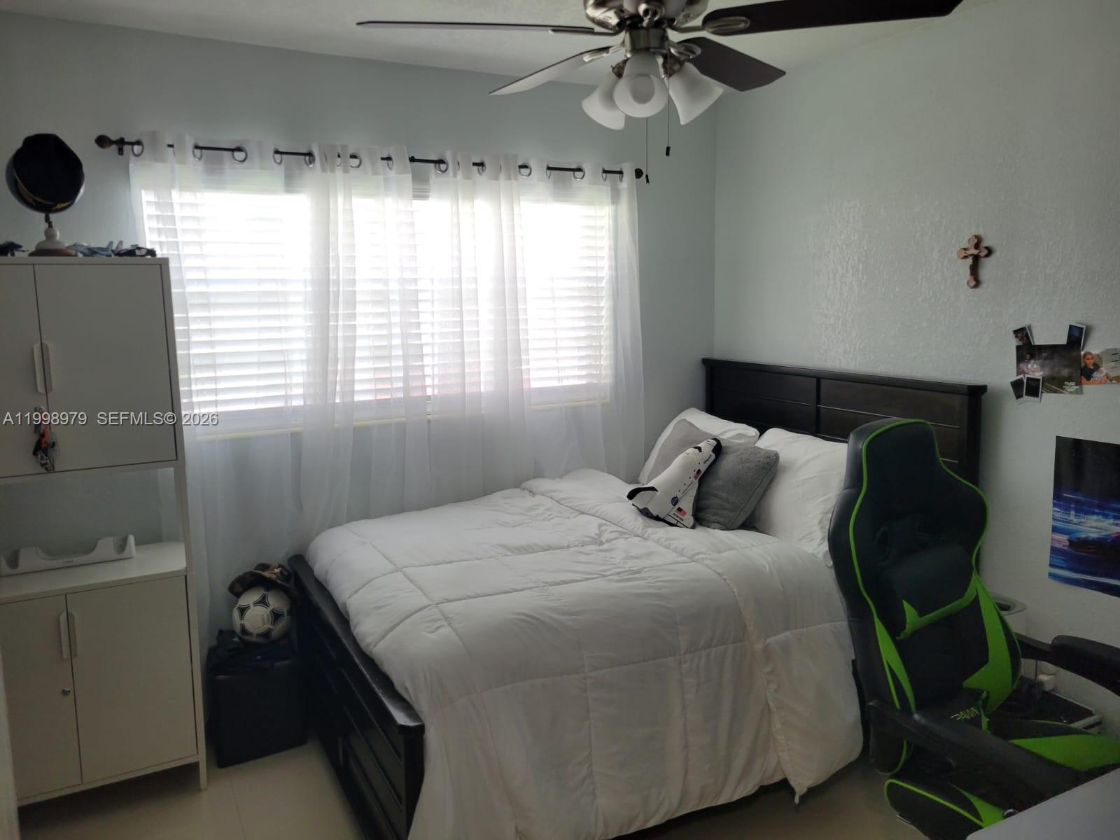 8245 Southwest 43rd Street Miami, FL 33155 - Photo 11 of 24 a bedroom with a bed and a chandelier