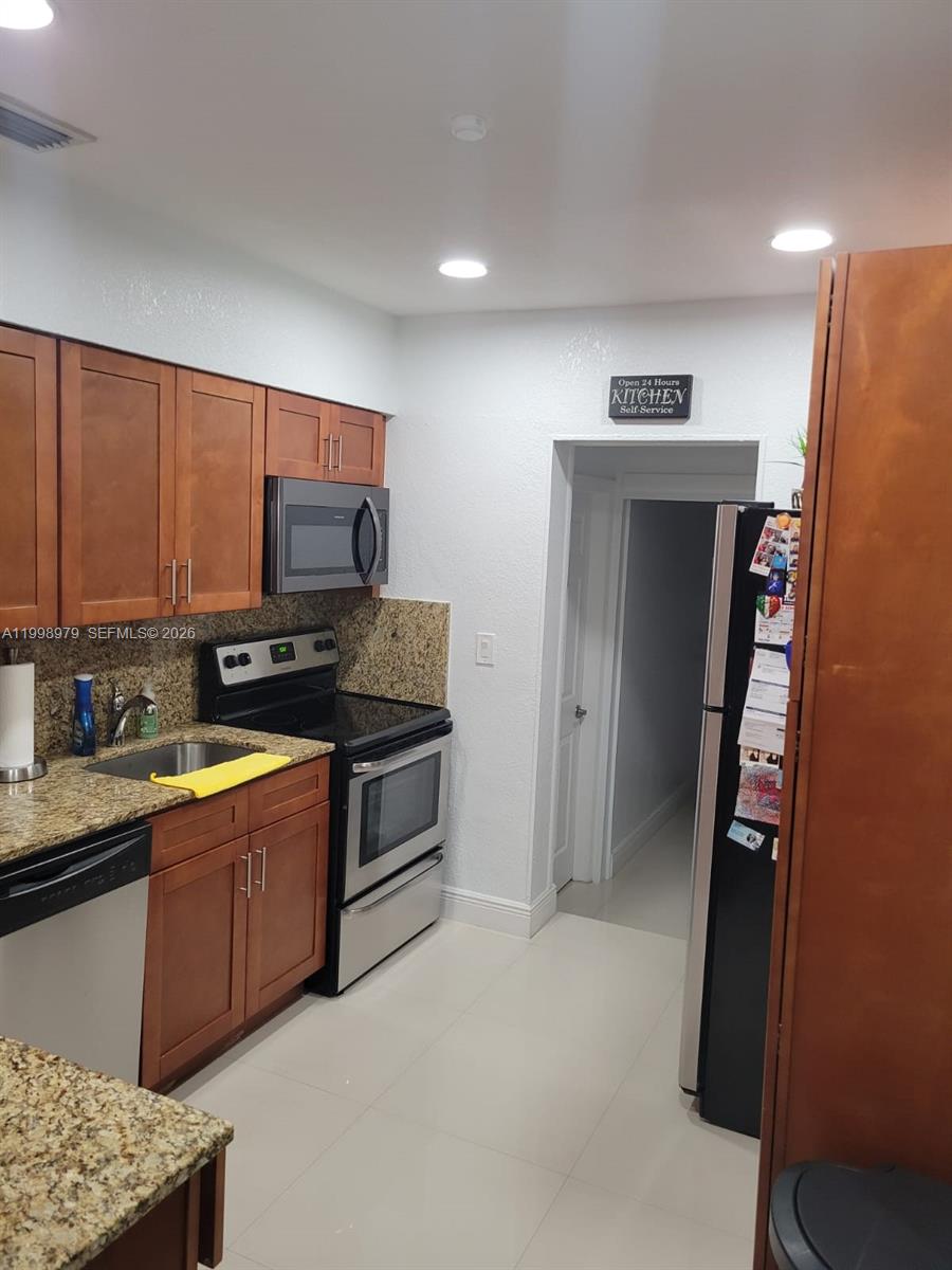8245 Southwest 43rd Street Miami, FL 33155 - Photo 14 of 24 a kitchen with stainless steel appliances granite countertop a refrigerator stove and sink