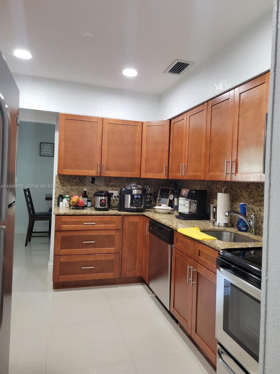 8245 Southwest 43rd Street Miami, FL 33155 - Photo 15 of 24 a kitchen with stainless steel appliances granite countertop a stove and a sink