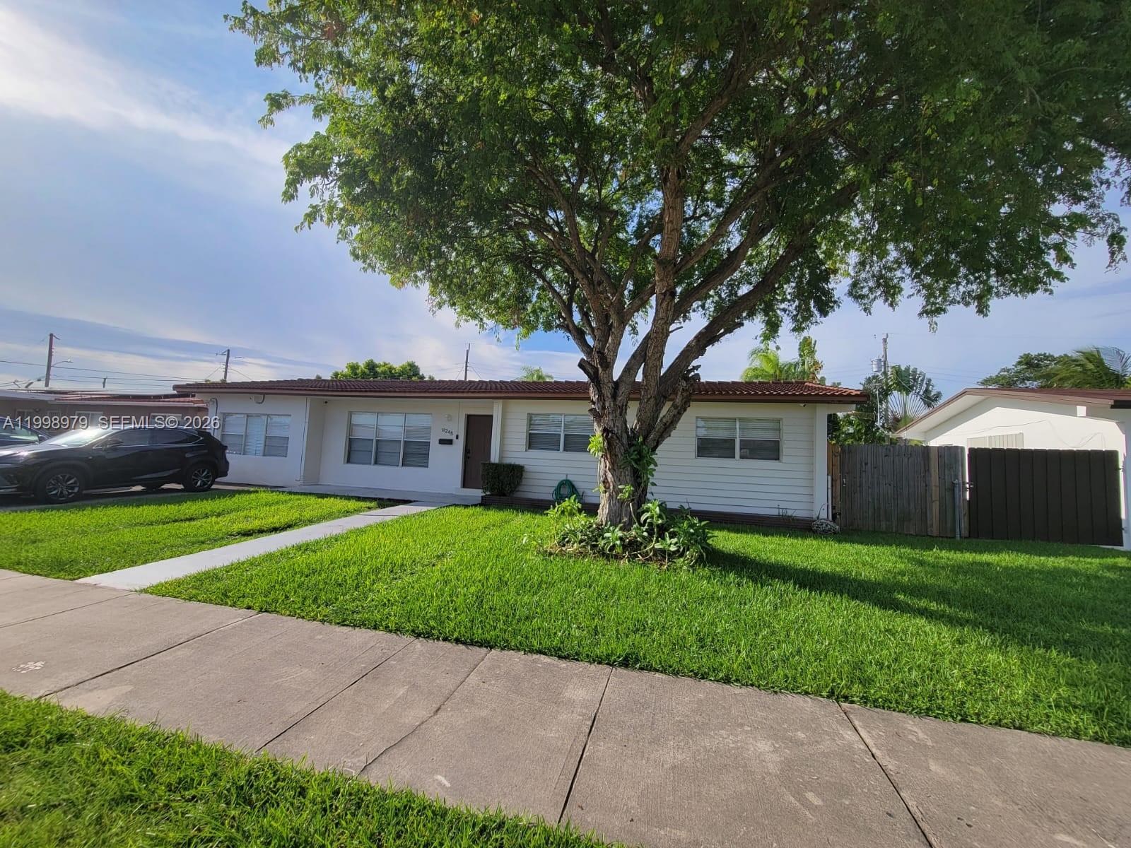 8245 Southwest 43rd Street Miami, FL 33155 - Photo 2 of 24 a front view of a house with a garden and trees