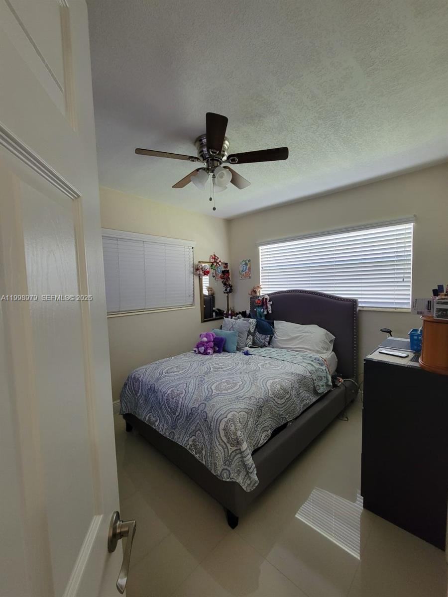 8245 Southwest 43rd Street Miami, FL 33155 - Photo 3 of 24 a bedroom with a bed and a chandelier