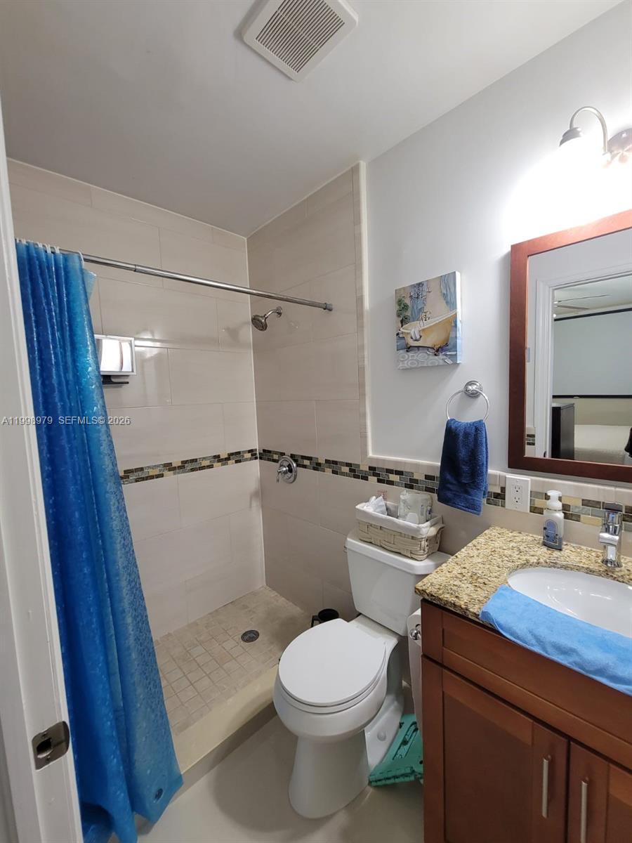 8245 Southwest 43rd Street Miami, FL 33155 - Photo 6 of 24 a bathroom with a sink a toilet a mirror and shower