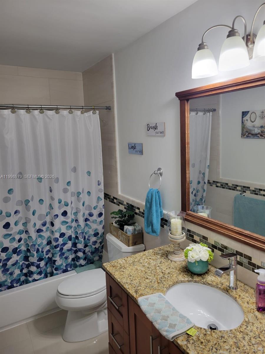 8245 Southwest 43rd Street Miami, FL 33155 - Photo 9 of 24 a bathroom with a granite countertop sink and a mirror
