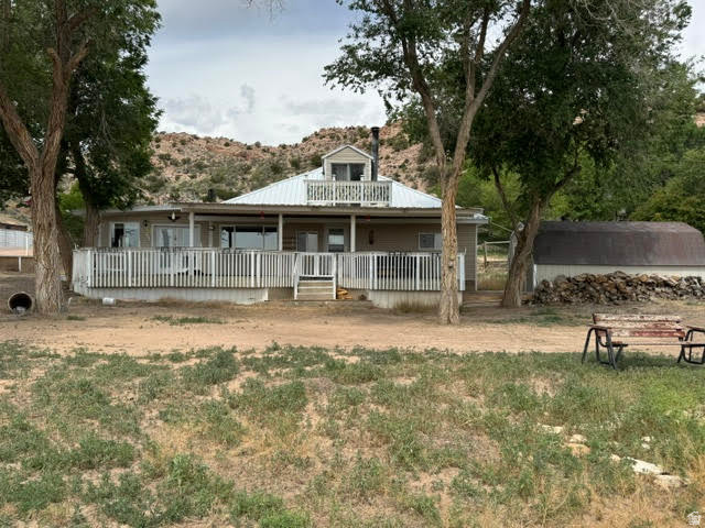 1124 Washam Road Green River, WY 82938 - Photo 1 of 35 Raised exterior with a full-length covered porch, white railing, and a second-story balcony