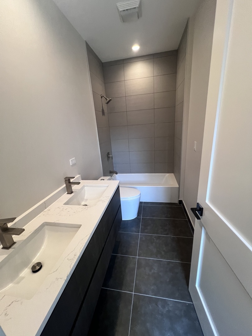 1039 West Belmont Avenue, Unit 4 Chicago, IL 60657 - Photo 14 of 22 a bathroom with a double vanity sink and a mirror