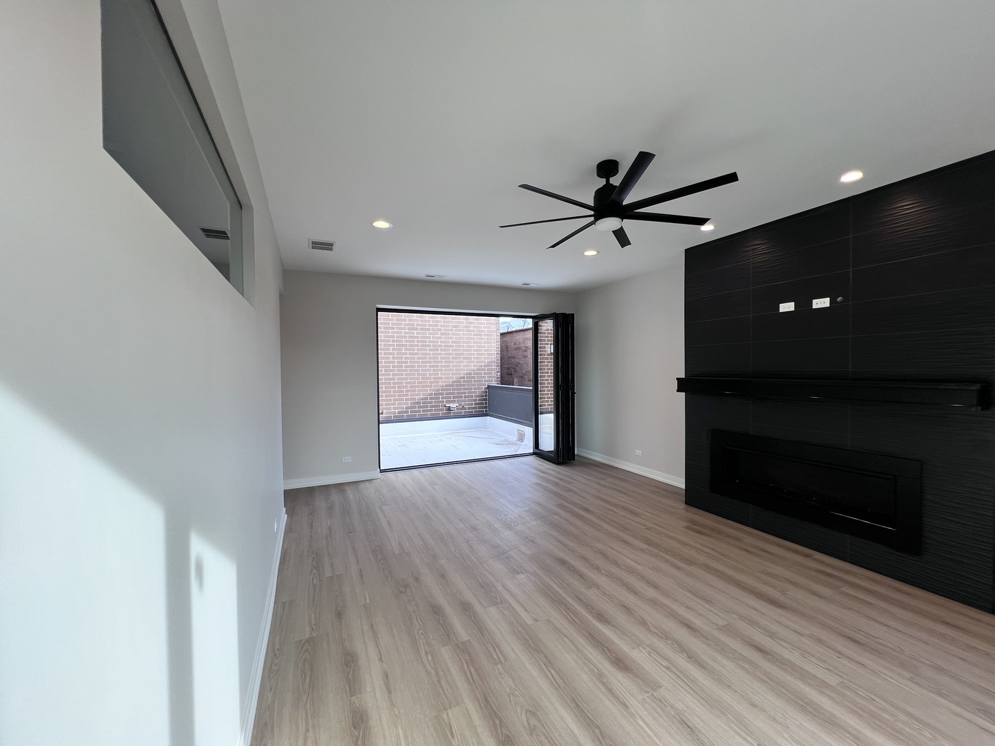 1039 West Belmont Avenue, Unit 4 Chicago, IL 60657 - Photo 15 of 22 a view of an empty room with wooden floor and a ceiling fan