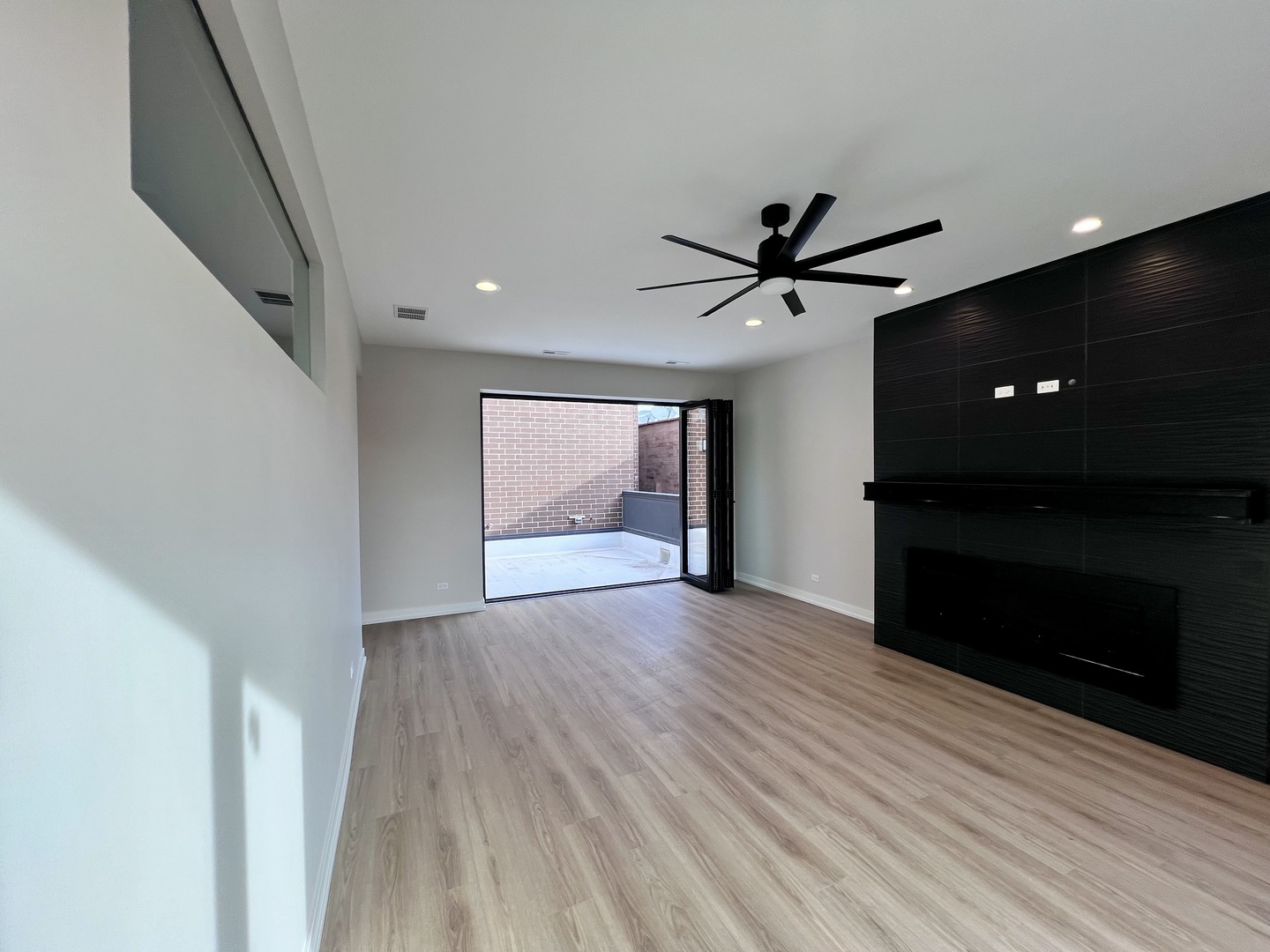 1039 West Belmont Avenue, Unit 4 Chicago, IL 60657 - Photo 20 of 22 a view of an empty room with a ceiling fan and wooden floor