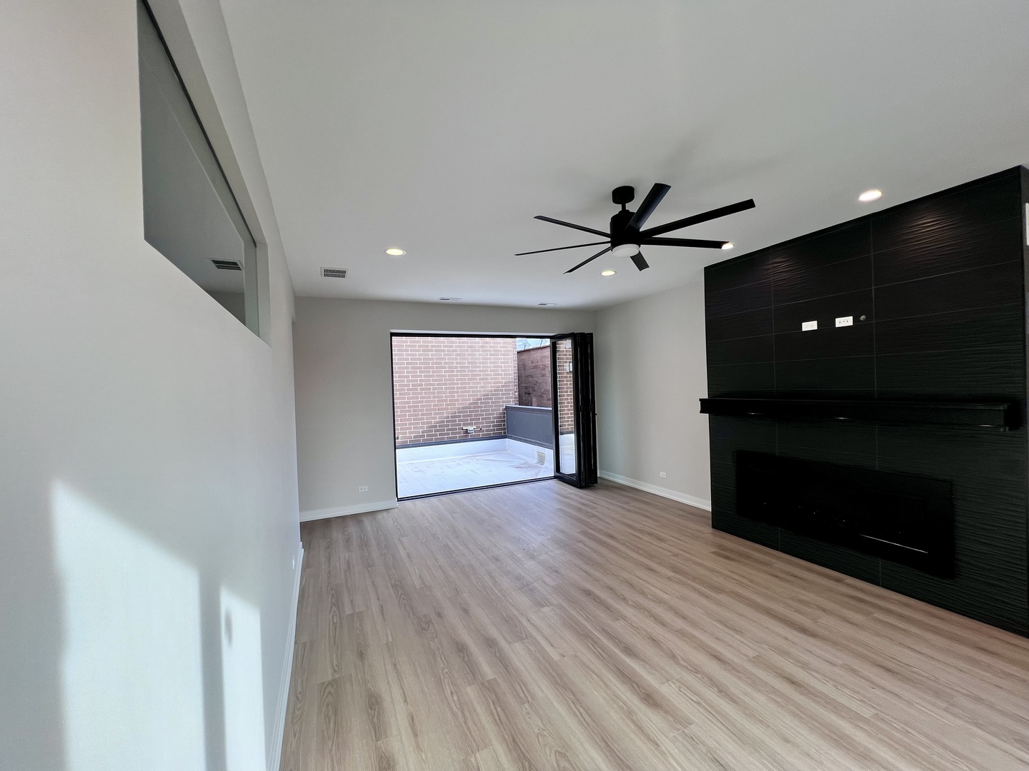 1039 West Belmont Avenue, Unit 4 Chicago, IL 60657 - Photo 8 of 22 a view of an empty room with wooden floor and a ceiling fan